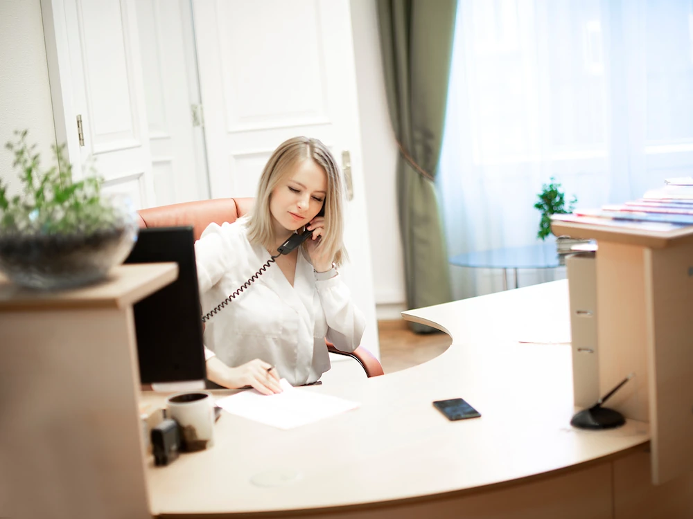 Woman answering the phone at receptionist desk of financial office