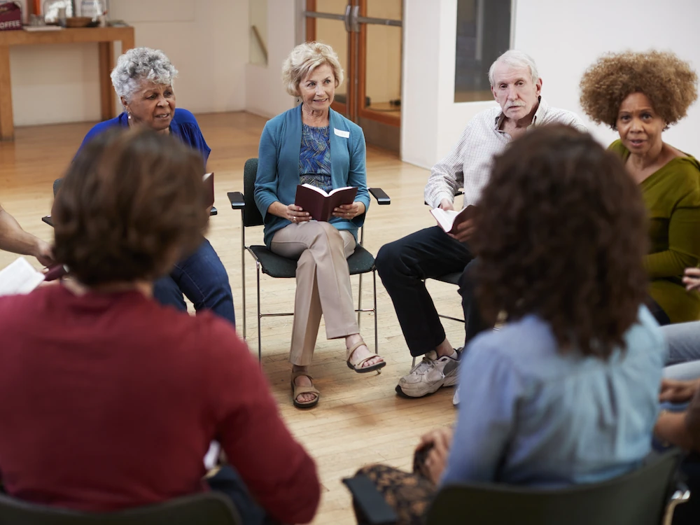Group of people sitting in a circle, sharing Bible study time together